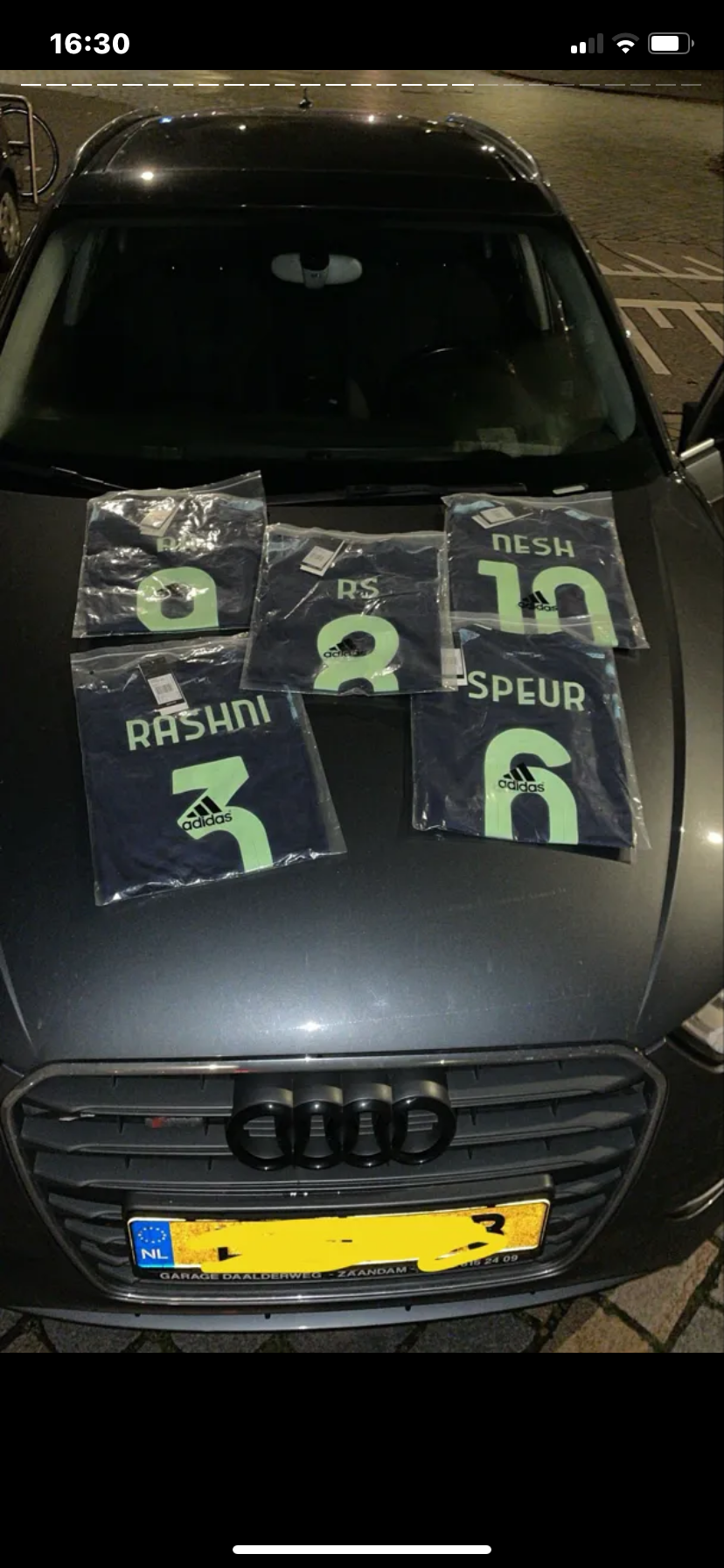Klantfoto van meerdere shirts op een auto