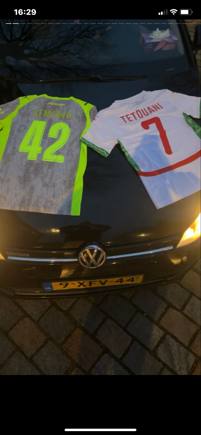 Klantfoto van twee voetbalshirts op een auto