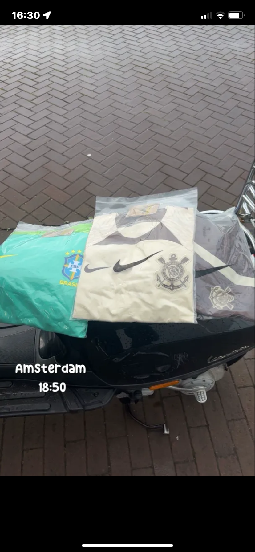 Klantfoto van drie ingepakte shirts op een scooter